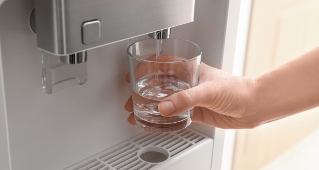 Vaso de agua en una de las fuentes de agua para oficinas